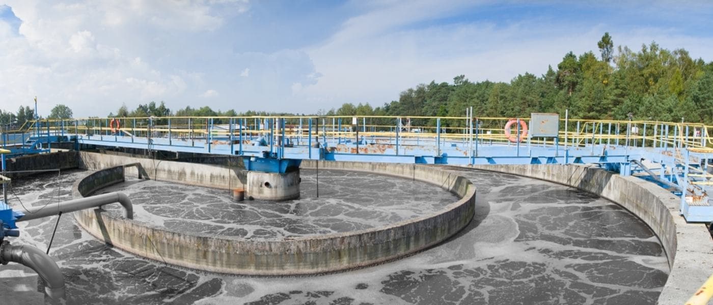 A circular clarifier with a rotating bridge mechanism at a wastewater treatment works.